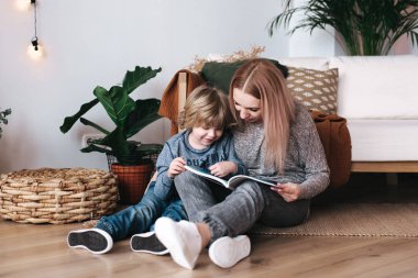 Anne ve oğul oturan ve okuma kitap birlikte evde