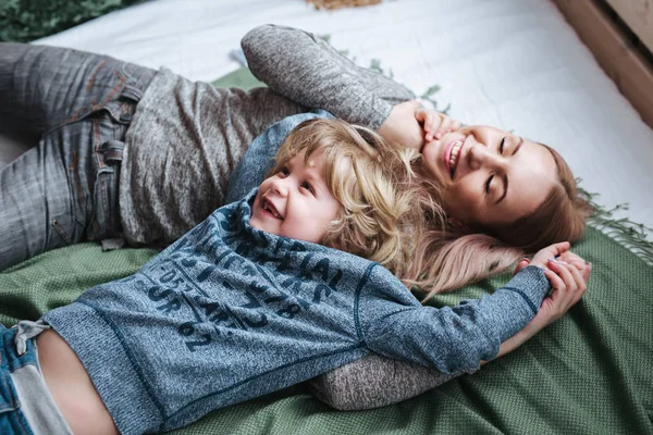 장난 기 넘치는 가족. 침대에서 웃 고 있는 어머니와 아기 아들 — 스톡 사진