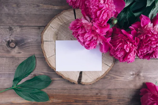 Flores de peonías rosadas y etiqueta vacía sobre fondo de madera envejecida. Vista superior con espacio de copia. Regalo Día de San Valentín . — Foto de Stock