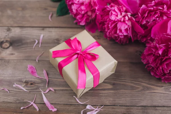 Rosa peônia flores copo caixa de presente na mesa rústica marrom. Dia das mães ou dia das mulheres — Fotografia de Stock