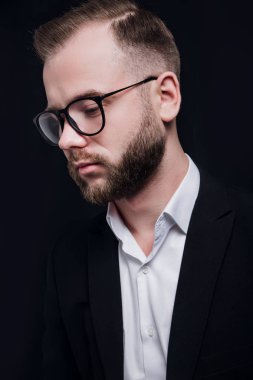 Siyah arka planda trendy elbise gözlük ile şık yakışıklı sakallı adam