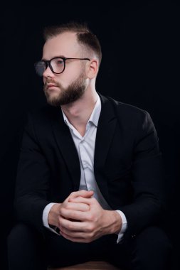 Siyah elbise ve gözlük siyah arka planda yakışıklı genç adam