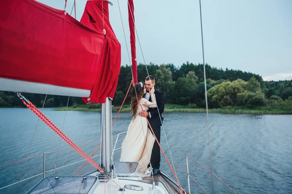 幸福的新娘和新郎在一艘游艇上拥抱 — 图库照片