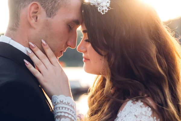 Close-up retrato de casamento casal abraçando no pôr do sol — Fotografia de Stock