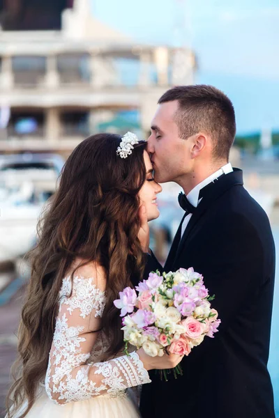 Noiva feliz e noivo beijando perto de iate na praia — Fotografia de Stock