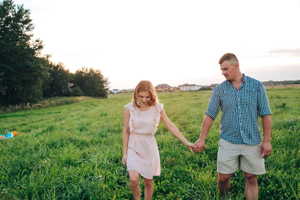 Молодая привлекательная пара влюблена в летний день в поле — стоковое фото
