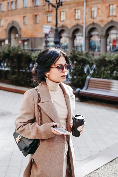 Stylish woman listning music on her airpods in city — Stock Photo, Image