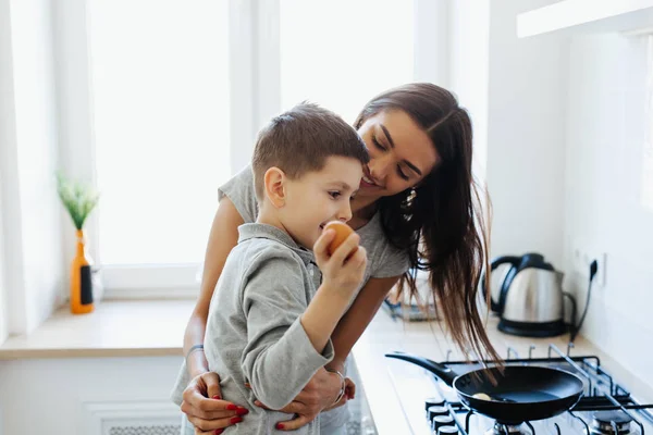 Gezond eten thuis. Gelukkige familie in de keuken. Moeder en kind dochter bereiden eieren — Stockfoto