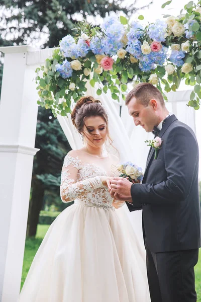 Groom usa um anel na mão da noiva na cerimônia de casamento — Fotografia de Stock