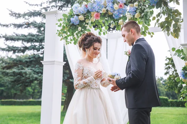 Noiva usa um anel na mão do noivo na cerimônia de casamento — Fotografia de Stock