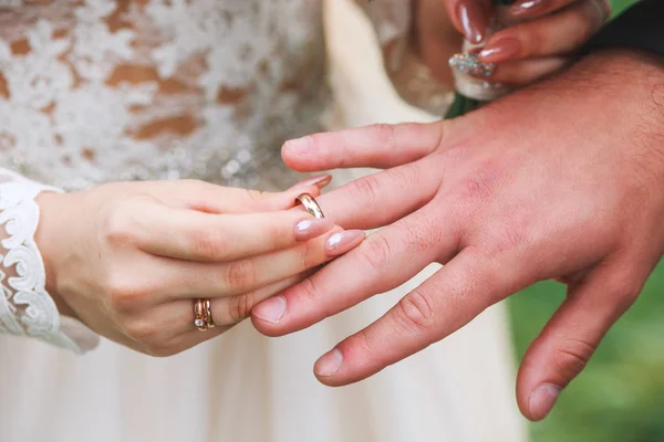 Bruid draagt een ring op de hand van de bruidegom op huwelijksceremonie buiten — Stockfoto