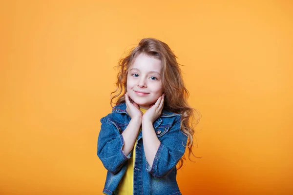 Studiový portrét usmívající se holčičky na žlutém pozadí — Stock fotografie