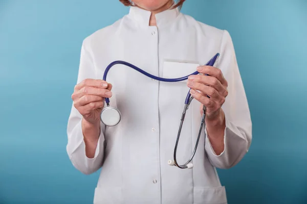 Close-up van de handen van de dokter met stethoscoop op blauwe achtergrond — Stockfoto