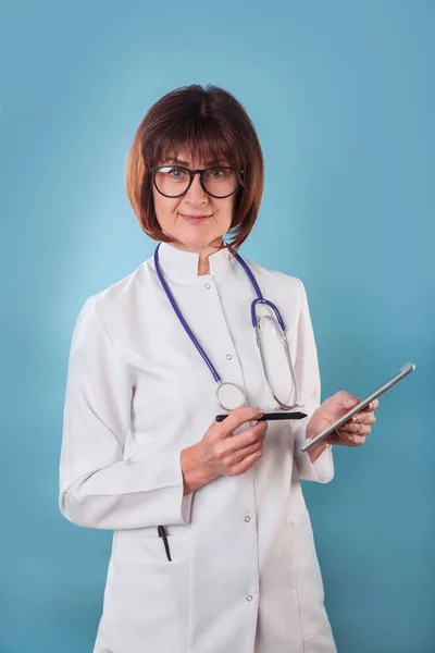 Smiling femal doctor portrait with clipboard on blue background