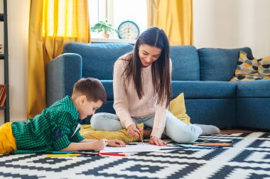 Genç Anne ve onun küçük oğul çizim birlikte evde.