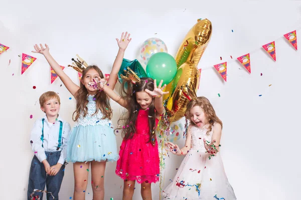 Grupo de crianças jogando confete colorido e olhando feliz na festa de aniversário — Fotografia de Stock