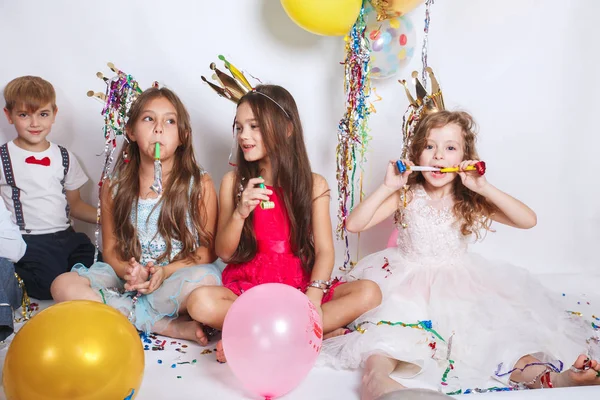 Grupa dzieci dobrze się bawiących i wyglądających szczęśliwie na urodzinach — Zdjęcie stockowe