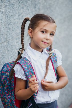 Sırt çantası ile Mutlu küçük kız öğrenci . Okula geri dön