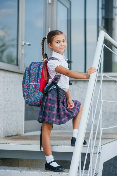 Portrait de belle jeune écolière avec sac à dos près de l'école — Photo