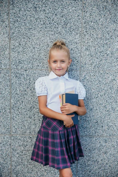 Portrét školní dívky v uniformě s knižní venkovní — Stock fotografie