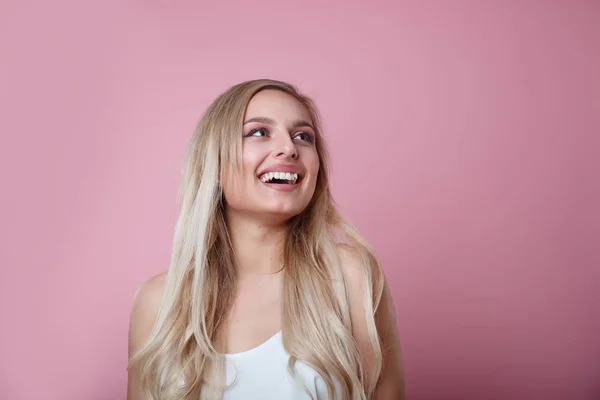 Mulher surpresa mostrando produto. Menina bonita com cabelo encaracolado apontando para o lado  . — Fotografia de Stock