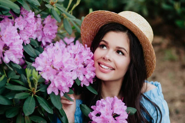 Portrait de belle jeune femme près de la floraison buisson en plein air — Photo