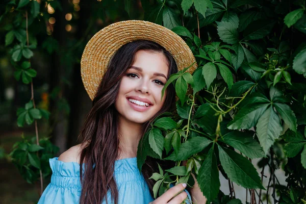 Naturligt skönhet. Attraktiv ung kvinna tittar på kamera och leende medan stående bland bladen utomhus — Stockfoto