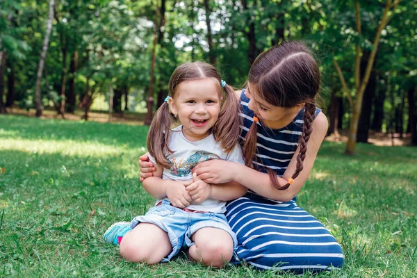 Två söta små flickor ha kul i parken i soliga sommardag — Stockfoto