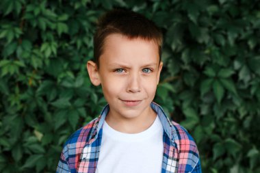 Portre mutlu gülümseyen çocuk açık bir damalı gömlek giyiyor