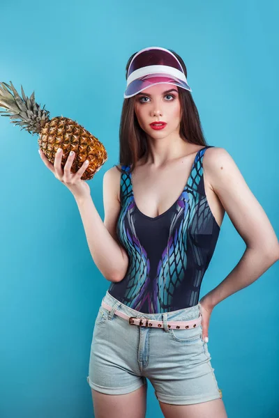 Fashion nyári portré gyönyörű nő v. rózsaszín napellenző és ananász mint a kék háttér — Stock Fotó