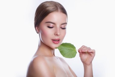 Temiz taze cilt ve yeşil yaprak ile güzel genç kadın. Kız Güzellik yüz bakımı. Yüz Bakımı .