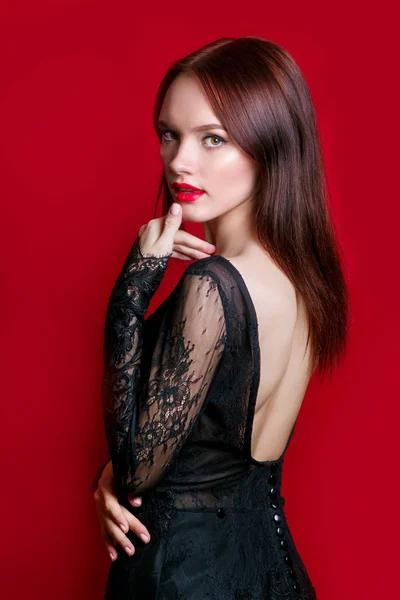 Increíble mujer de lujo en vestido de fiesta negro elegante posando sobre fondo rojo. Celebrando fiesta de cumpleaños . — Foto de Stock