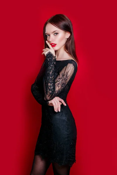 Retrato de mulher sensual elegante lindo vestindo vestido preto moda no fundo vermelho — Fotografia de Stock