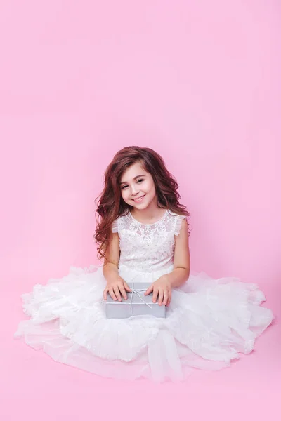 Niña cumpleaños estudio retrato en rosa pared chica apertura regalo emocionado — Foto de Stock