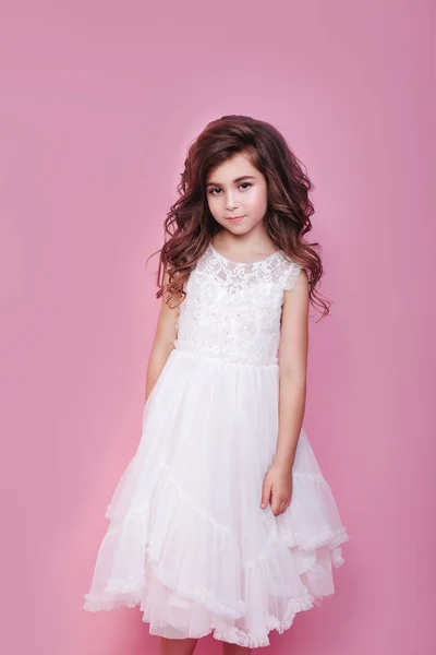 Πορτρέτο του όμορφο μικρό κορίτσι σε λευκό φόρεμα σε ροζ φόντο — Φωτογραφία Αρχείου