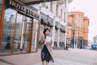 Şehir caddesinde dizüstü bilgisayar ile başarılı işadamı