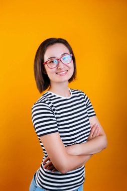 dost asyalı kadın çapraz kolları ile ayakta, bir şey gülüyor, kameraya bakarak.