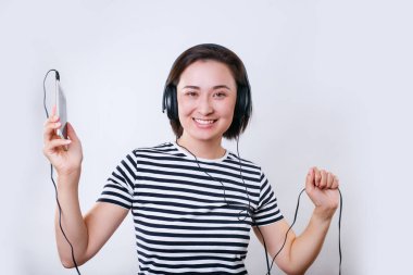 genç gülümseyen asyalı kadın kulaklık ve dans müzik dinliyor