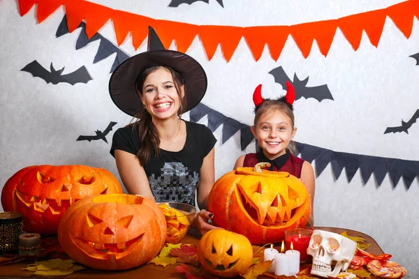 Mutter und Tochter amüsieren sich zu Hause. glückliche Familie bereitet sich auf halloween vor. Menschen in Karnevalskostümen. — Stockfoto