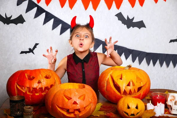 Boldog Halloweent! Aranyos vicces kislány faragott sütőtökkel. Boldog családi felkészülés Halloweenre. — Stock Fotó