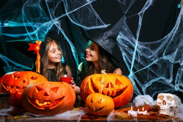 Mor och hennes dotter i häxa kostymer har roligt hemma. Lycklig familj förbereda för Halloween. — Stockfoto