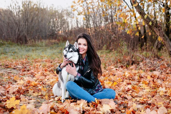 Όμορφη γυναίκα και το σκυλί της ποζάρουν έξω στο πάρκο φθινόπωρο — Φωτογραφία Αρχείου