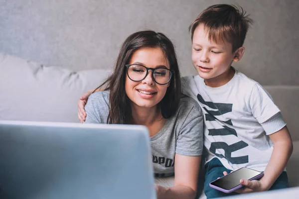 Kisfiú és az anyja videokonferencián a tanár a laptop otthon. — Stock Fotó