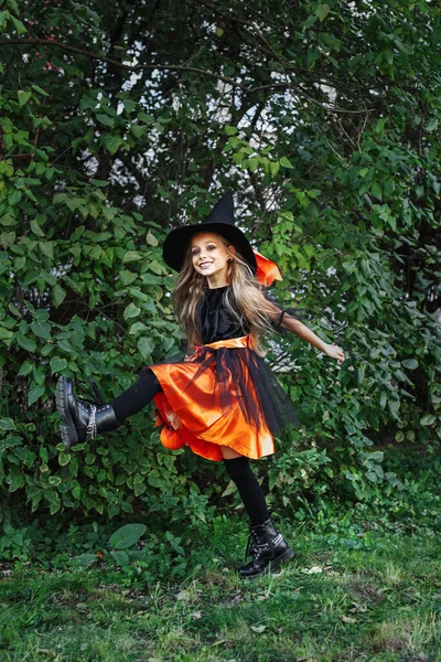 Menina em traje de bruxa no truque de Halloween ou tratar ao ar livre — Fotografia de Stock