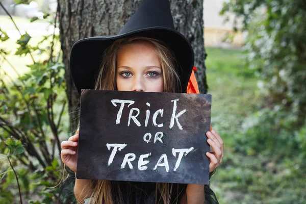 Klein meisje in Halloween kostuum truc of traktatie — Stockfoto