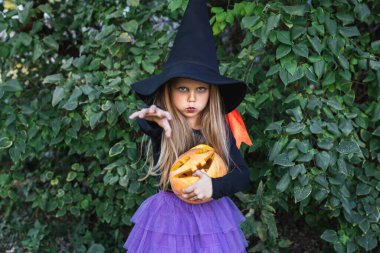 Cadılar Bayramı 'nda cadı kostümü giymiş küçük kız şeker toplamaya çıktı.