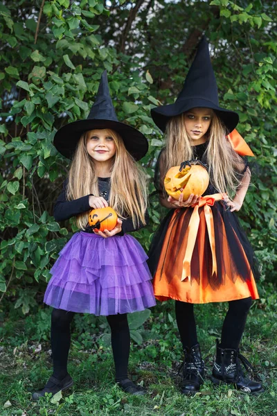 Lachende lustige Kindermädchen im Hexenkostüm zu Halloween im Freien — Stockfoto