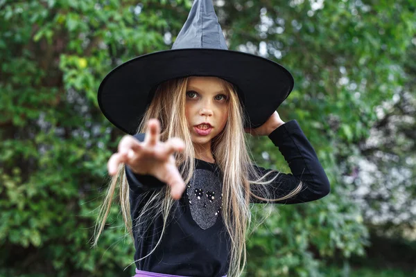 Niña con disfraz de bruja divirtiéndose en truco o trato de Halloween — Foto de Stock