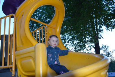 Yılın ılık zamanlarında dışarıda bir çocuk oyun bahçesinde oynuyor.. 