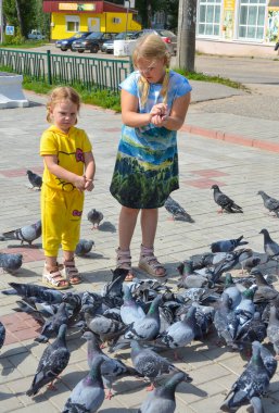 Sokakta, kızlar güvercin tohumlarını besler.. 